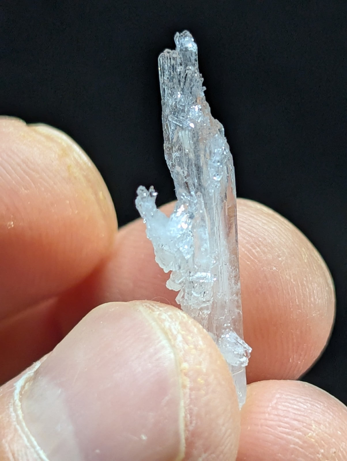 A translucent, crystalline mineral specimen with a jagged, multi-faceted structure and subtle blue tint.