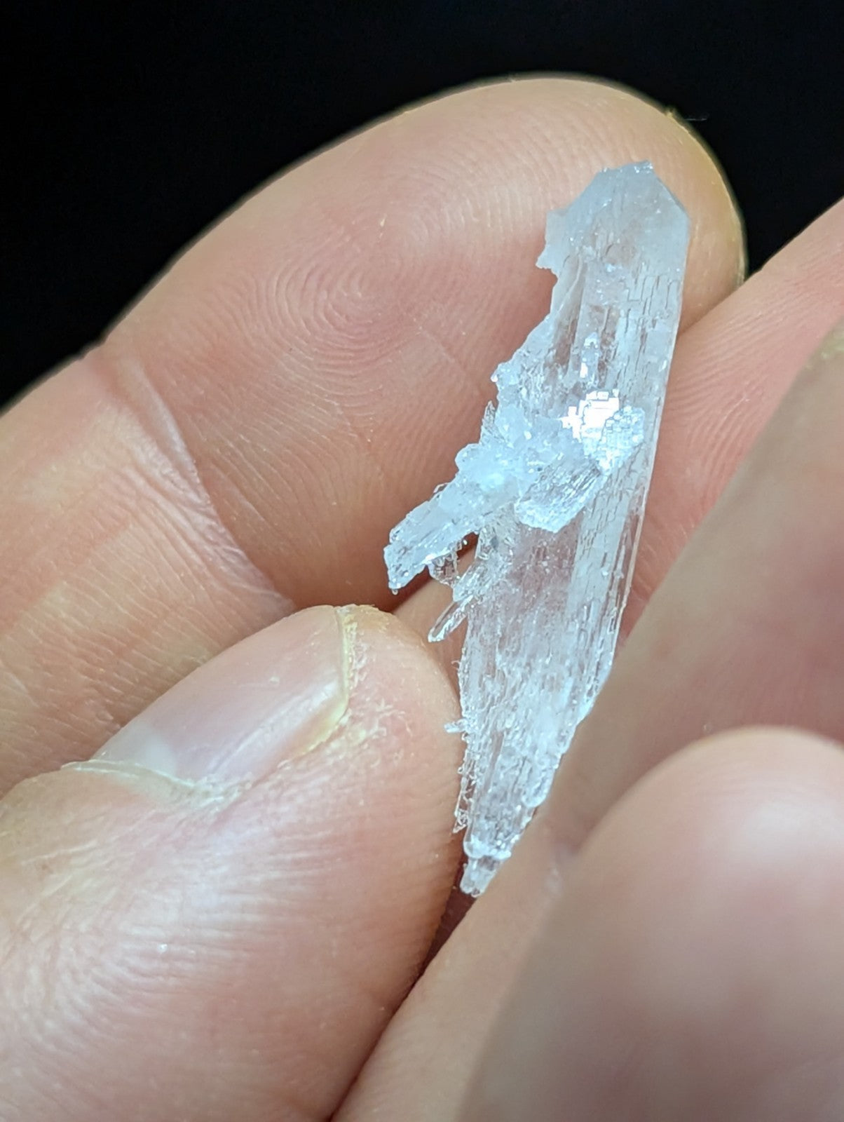 A translucent, crystalline mineral specimen with jagged edges and a glassy sheen.