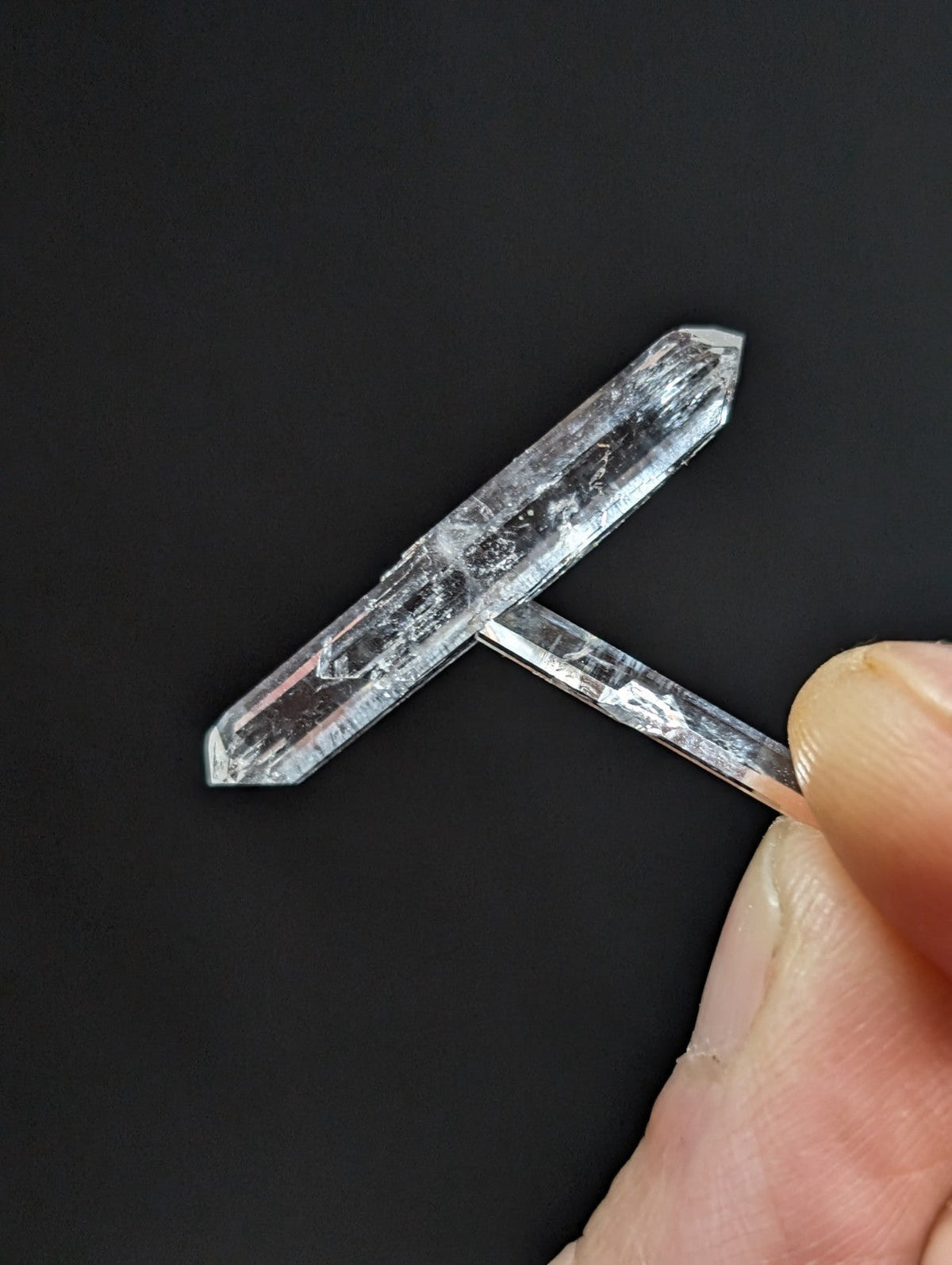 A clear, translucent quartz crystal with a natural, faceted cut and subtle internal inclusions.