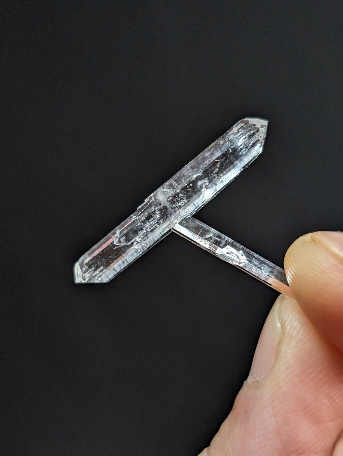A clear, translucent quartz crystal with a natural, faceted cut and subtle internal inclusions.