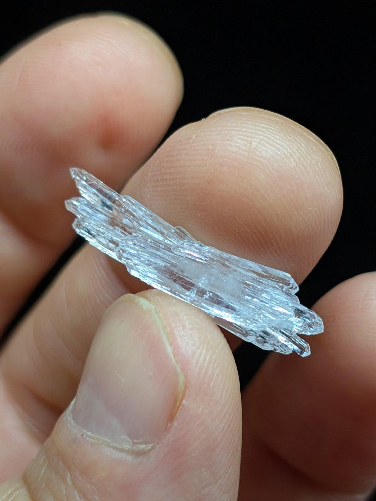 A translucent, crystalline mineral specimen with sharp, jagged edges and a pale blue hue.
