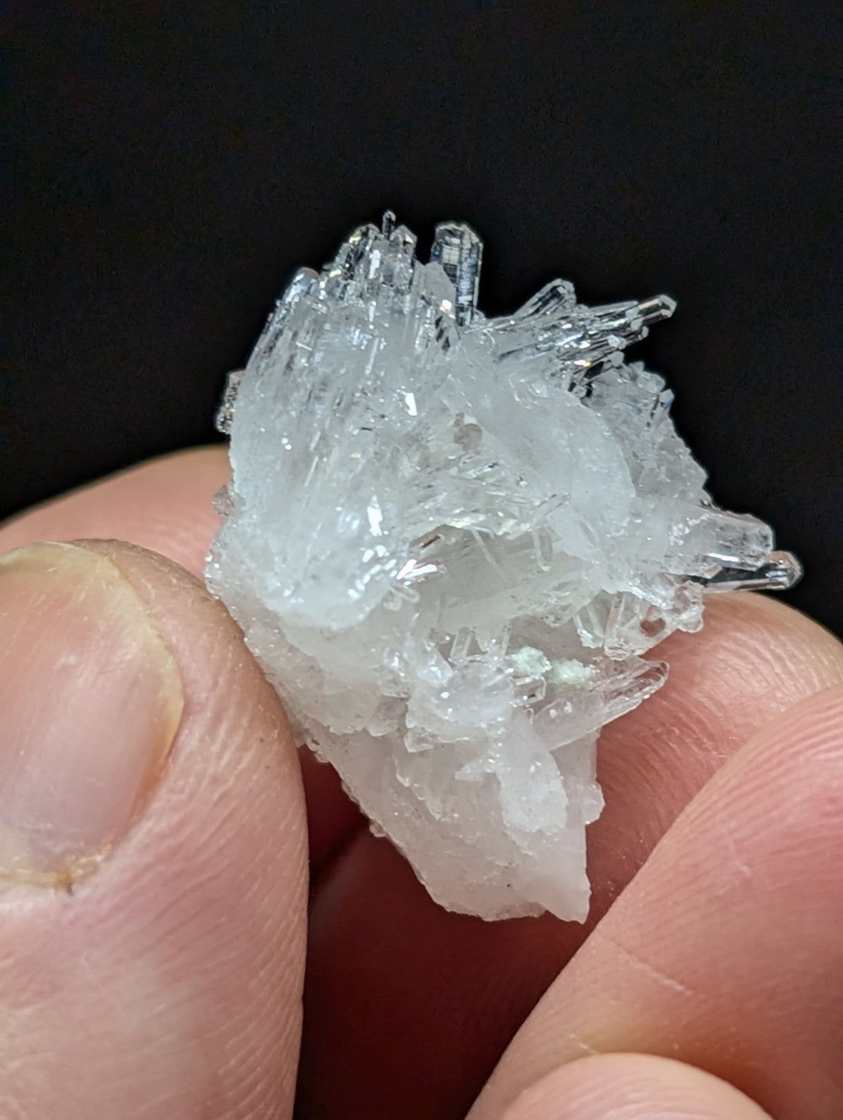 A translucent, crystalline mineral specimen with sharp, jagged facets and a pale, icy white hue.