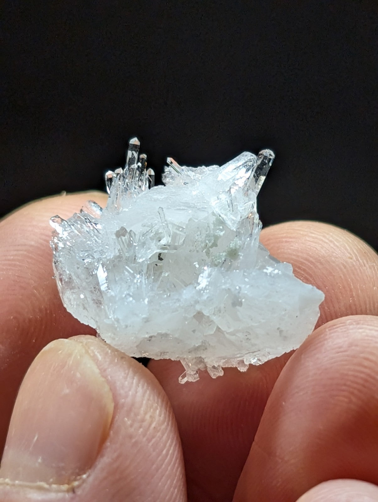 A translucent, crystalline mineral specimen with sharp, jagged facets and a pale white hue.