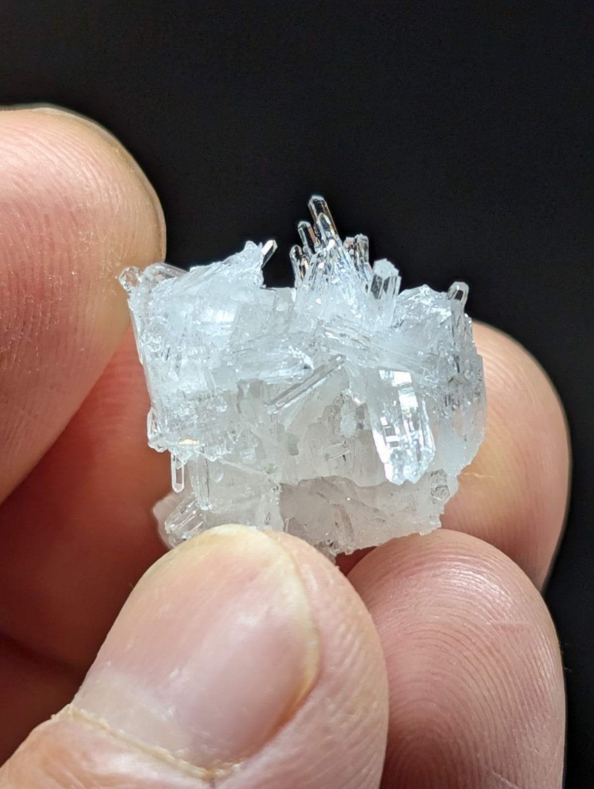A translucent, crystalline mineral specimen with sharp, jagged facets and a clear, glassy appearance.