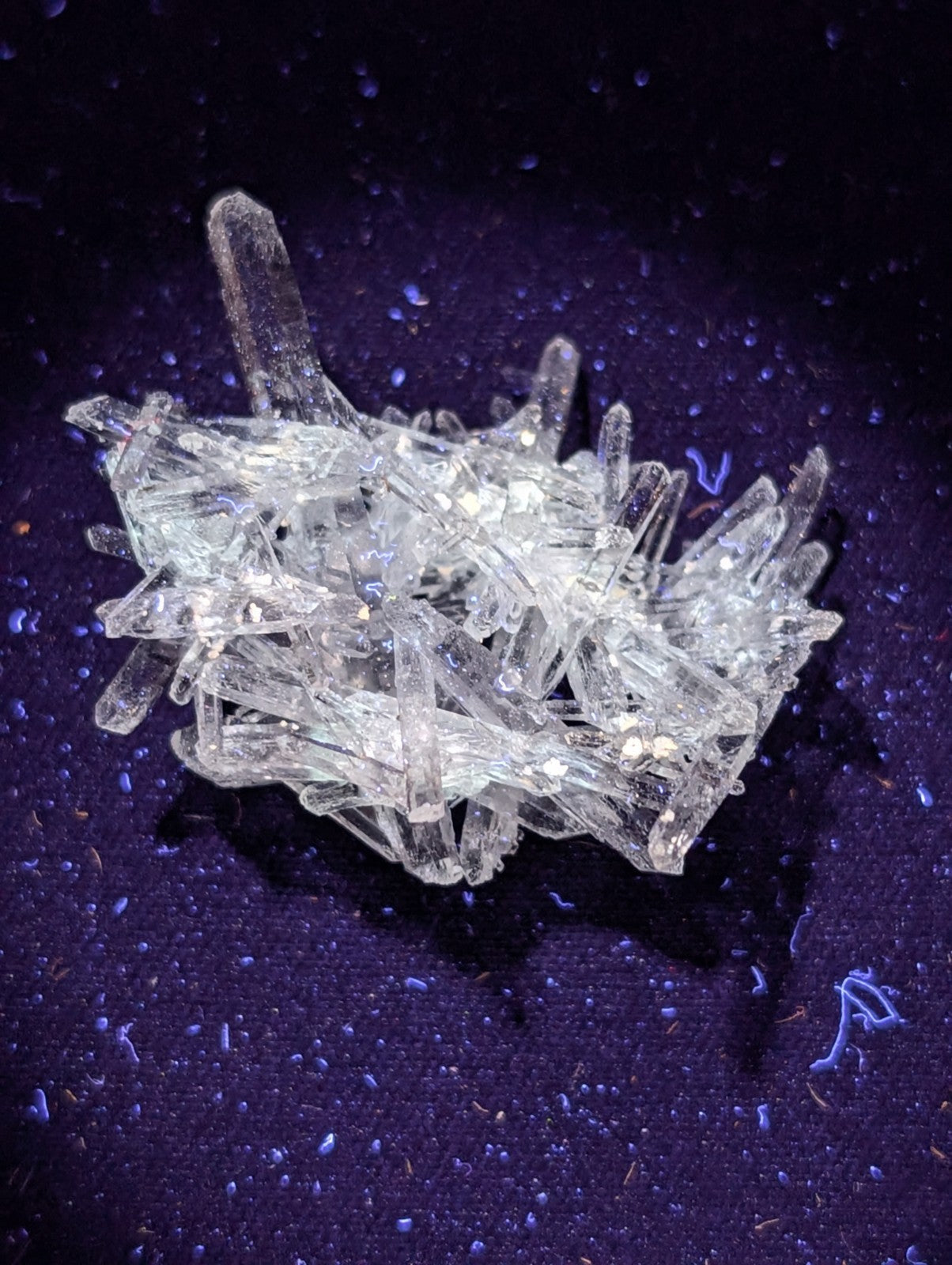 A cluster of transparent, crystalline quartz formations with sharp, angular facets and a glassy sheen.