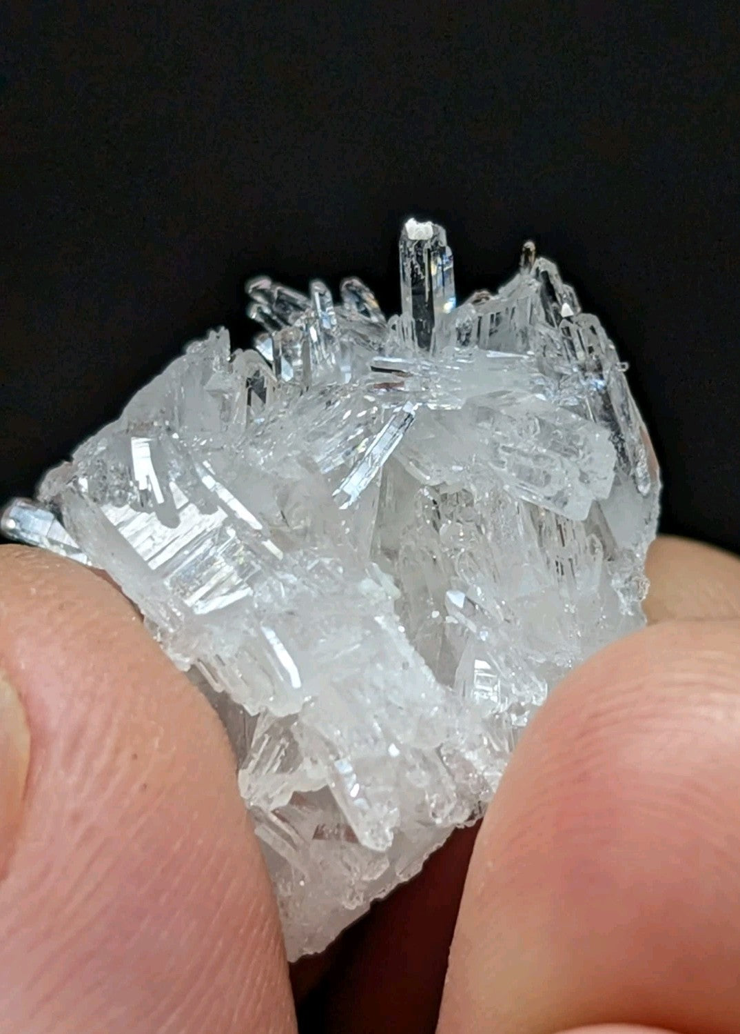 A clear, translucent crystal cluster with sharp, jagged edges and a natural, earthy formation.