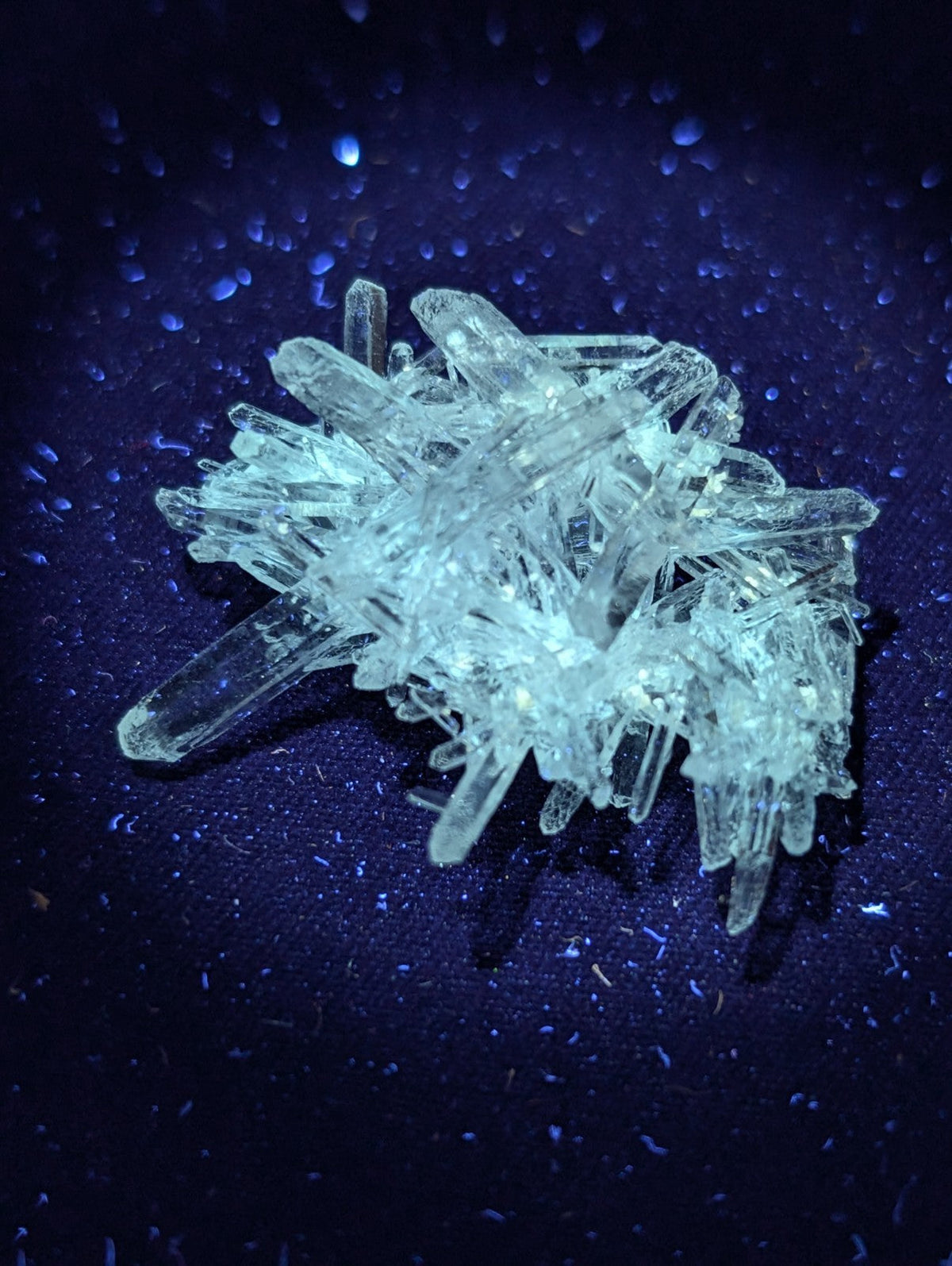 A cluster of transparent, crystalline quartz formations with sharp, angular facets and a pale blue tint.