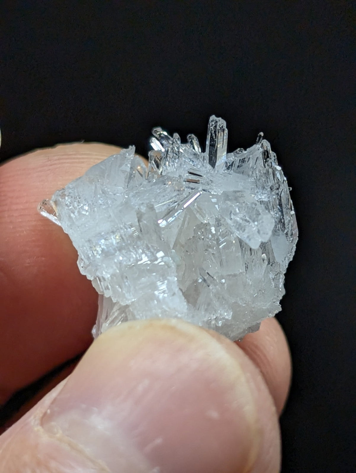 A translucent, crystalline mineral specimen with sharp, jagged edges and a clear, glassy appearance.