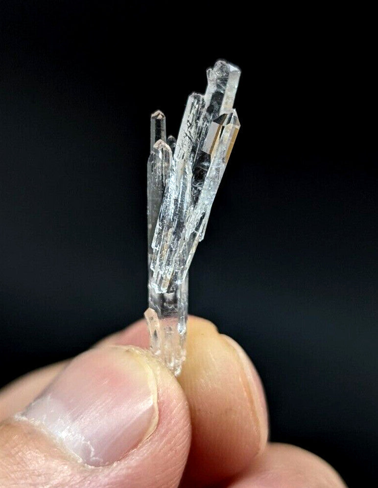 A clear, translucent quartz crystal cluster with sharp, faceted points and a natural, branching structure.