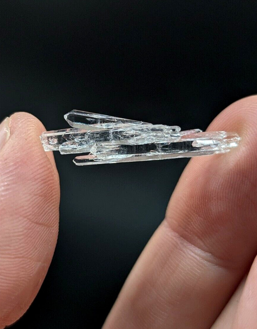 A clear, transparent quartz crystal cluster with multiple interlocking prismatic points.