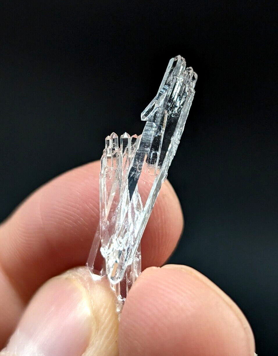 A clear, transparent quartz crystal cluster with sharp, faceted edges and a natural, branching structure.