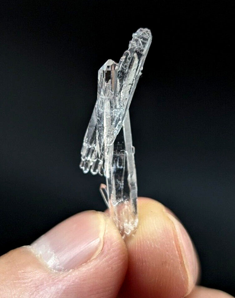 A clear, translucent quartz crystal cluster with intricate branching formations and a natural, faceted appearance.