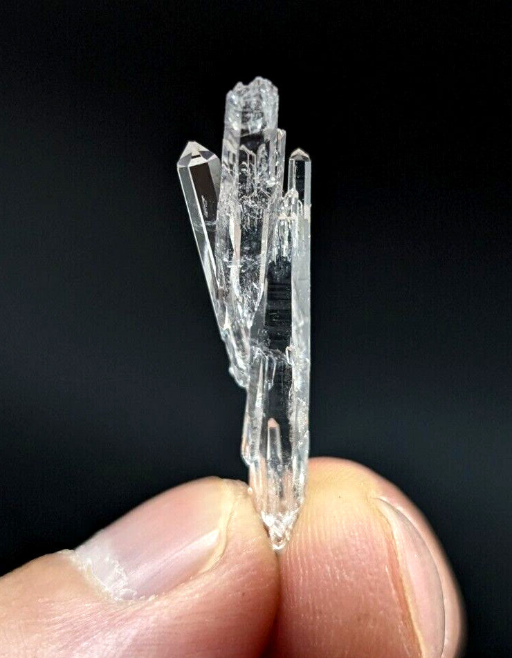 A clear, transparent quartz crystal cluster with sharp, faceted points and a natural, jagged growth pattern.