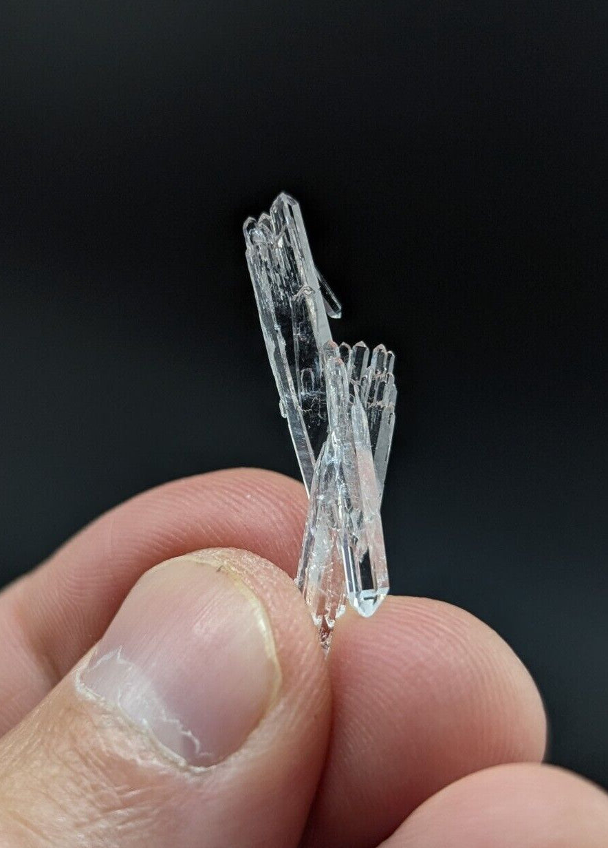 A clear, translucent quartz crystal cluster with sharp, angular facets and a delicate branching structure.