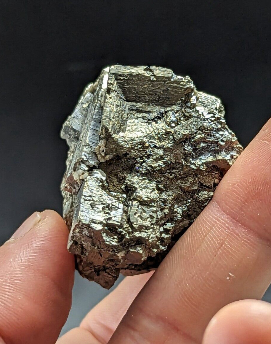 A metallic, silver-gray pyrite crystal with a rough, jagged surface and visible crystalline facets.