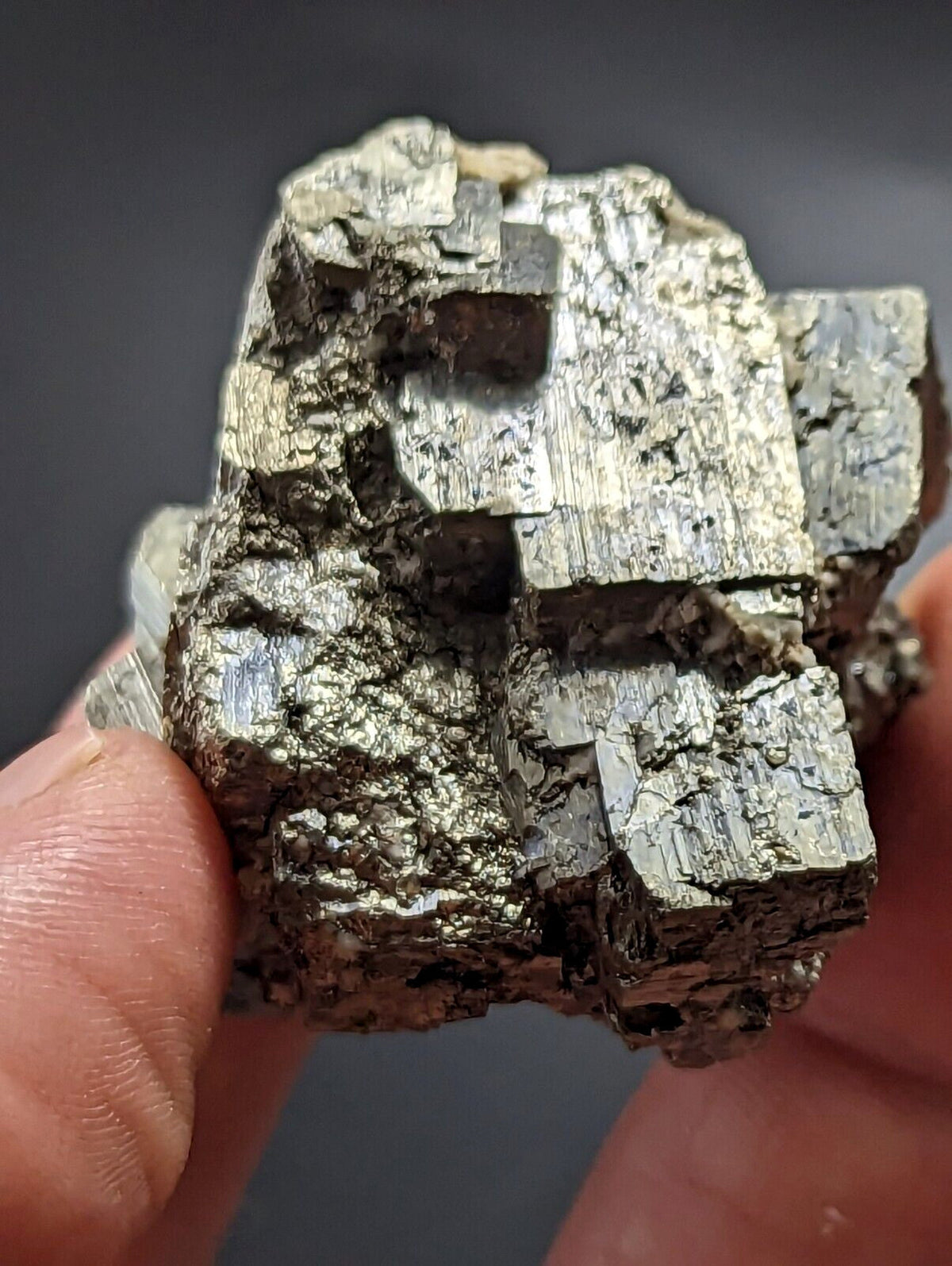 A metallic, silver-gray mineral specimen with a rough, crystalline surface and visible facets.