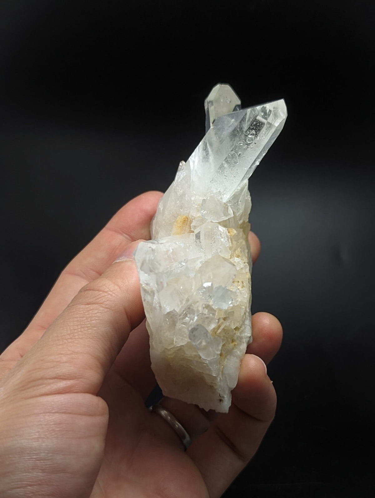 A translucent white quartz crystal cluster with sharp, faceted points and a rougher base.