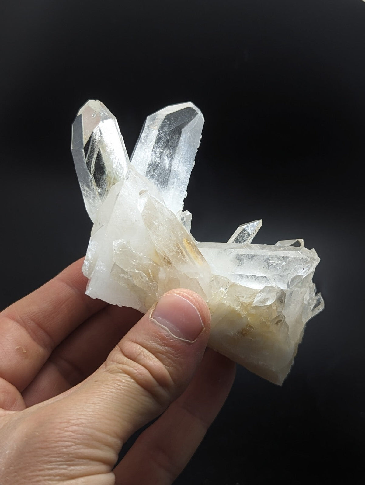 A translucent white quartz crystal cluster with sharp, faceted points and a slightly cloudy base.