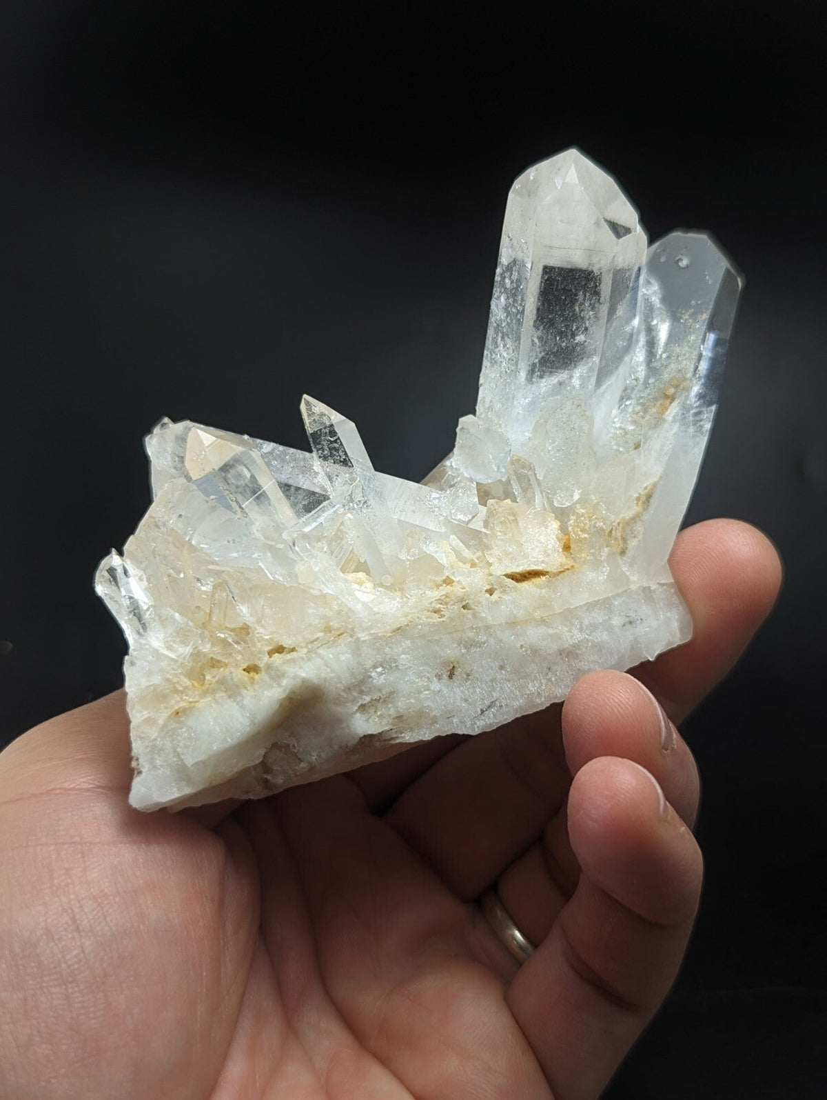 A translucent quartz crystal cluster with clear, pointed formations and a white base.