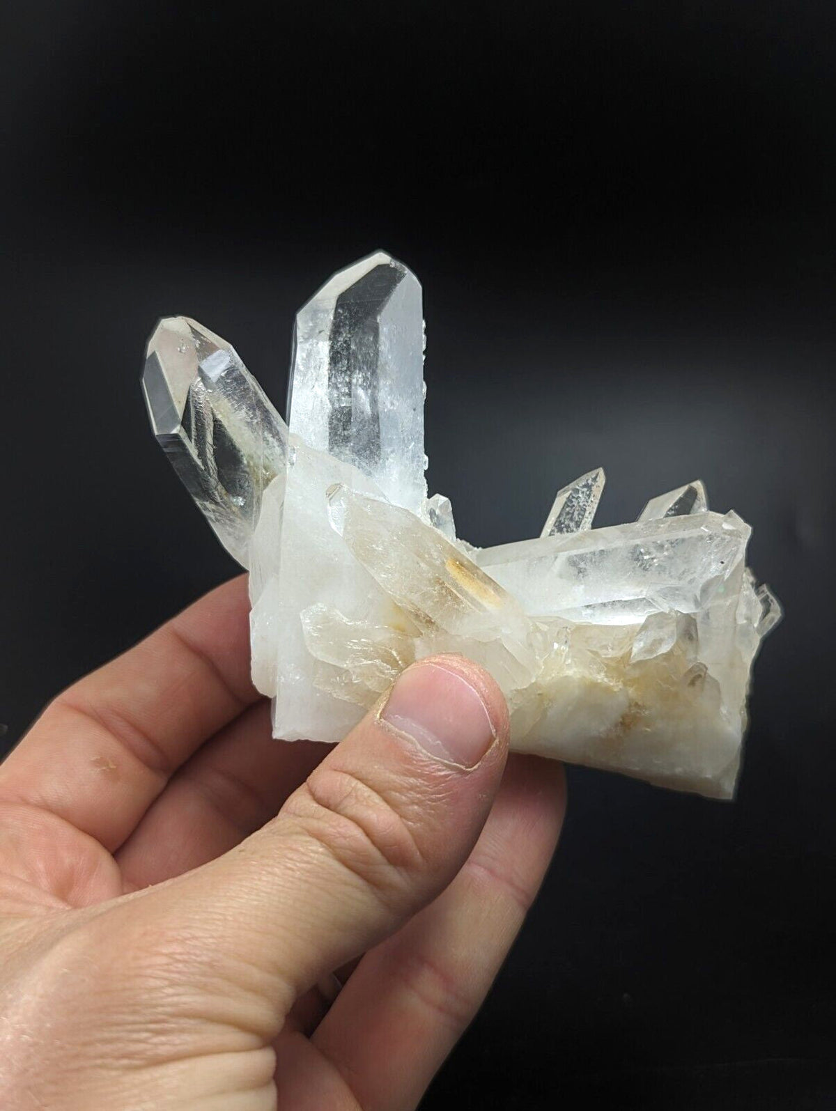 A translucent quartz crystal cluster with clear, pointed facets and a base of milky white material.