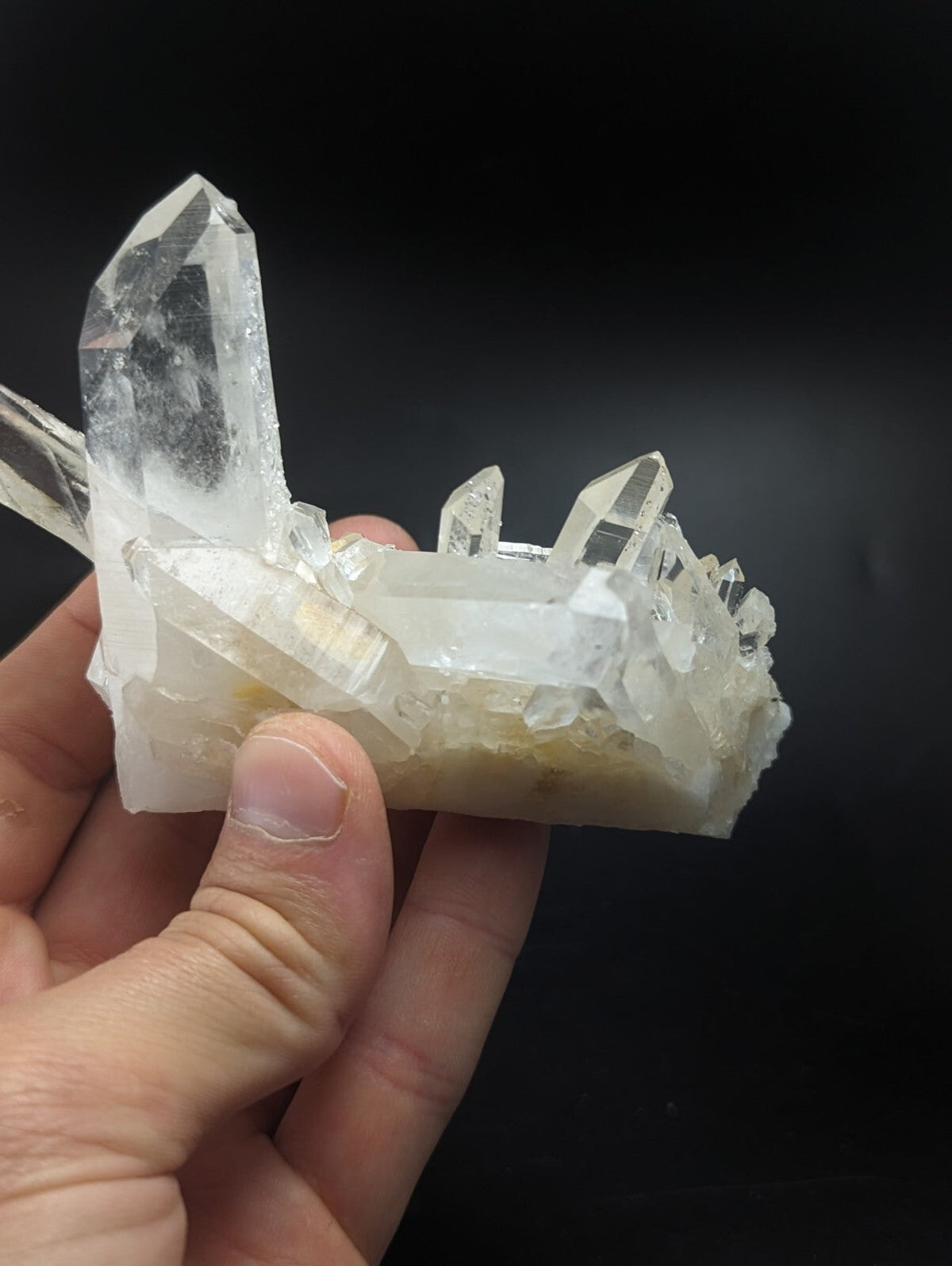 A translucent white quartz crystal cluster with sharp, pointed facets and a natural base.