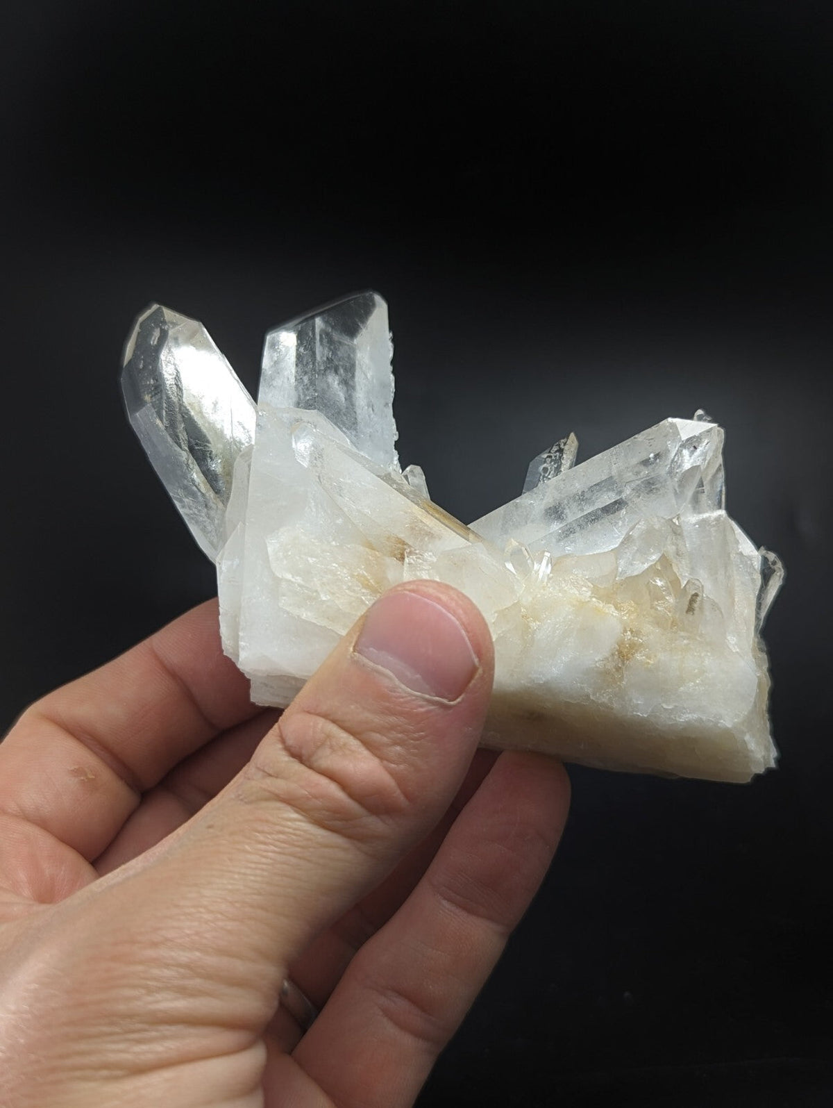 A translucent white quartz crystal cluster with sharp, faceted points and a slightly cloudy base.