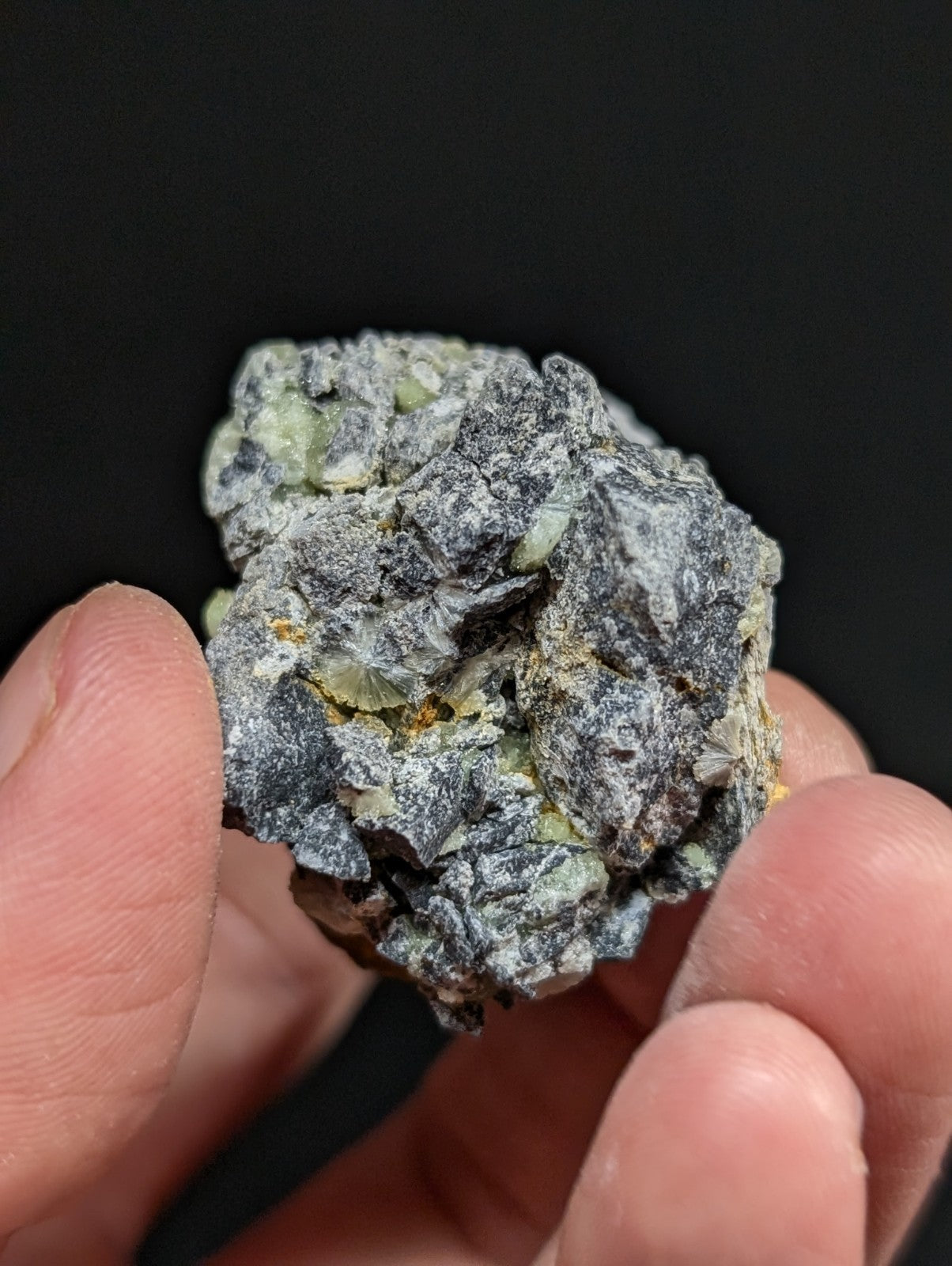 A rough, irregularly shaped mineral specimen with a mottled gray and pale green surface.