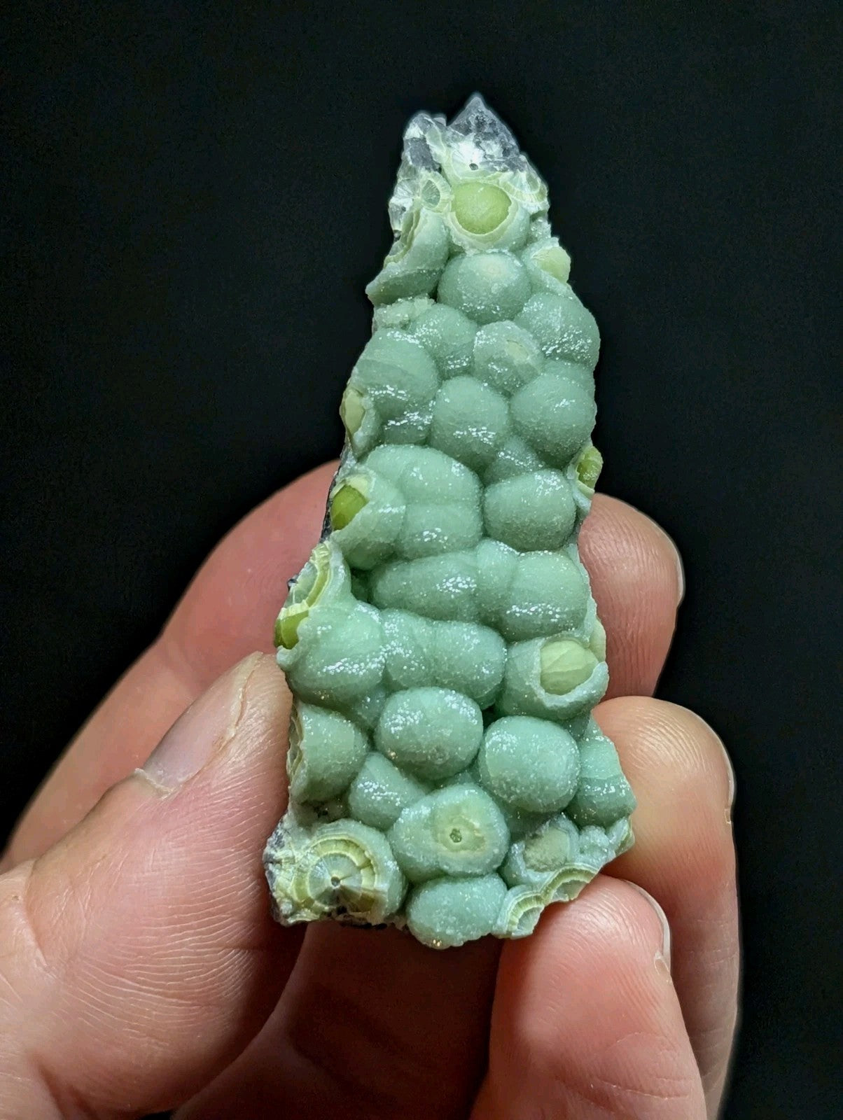 A pale green, textured mineral specimen with rounded nodules and a crystalline top.
