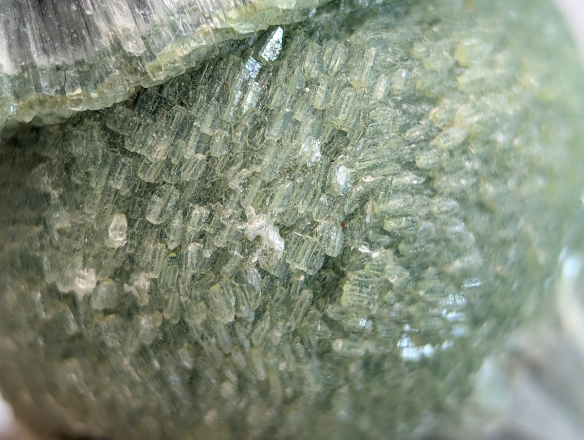 A translucent green wavellite mineral cluster with yellow undertones on a handmade wood mount from Garland County Arkansas