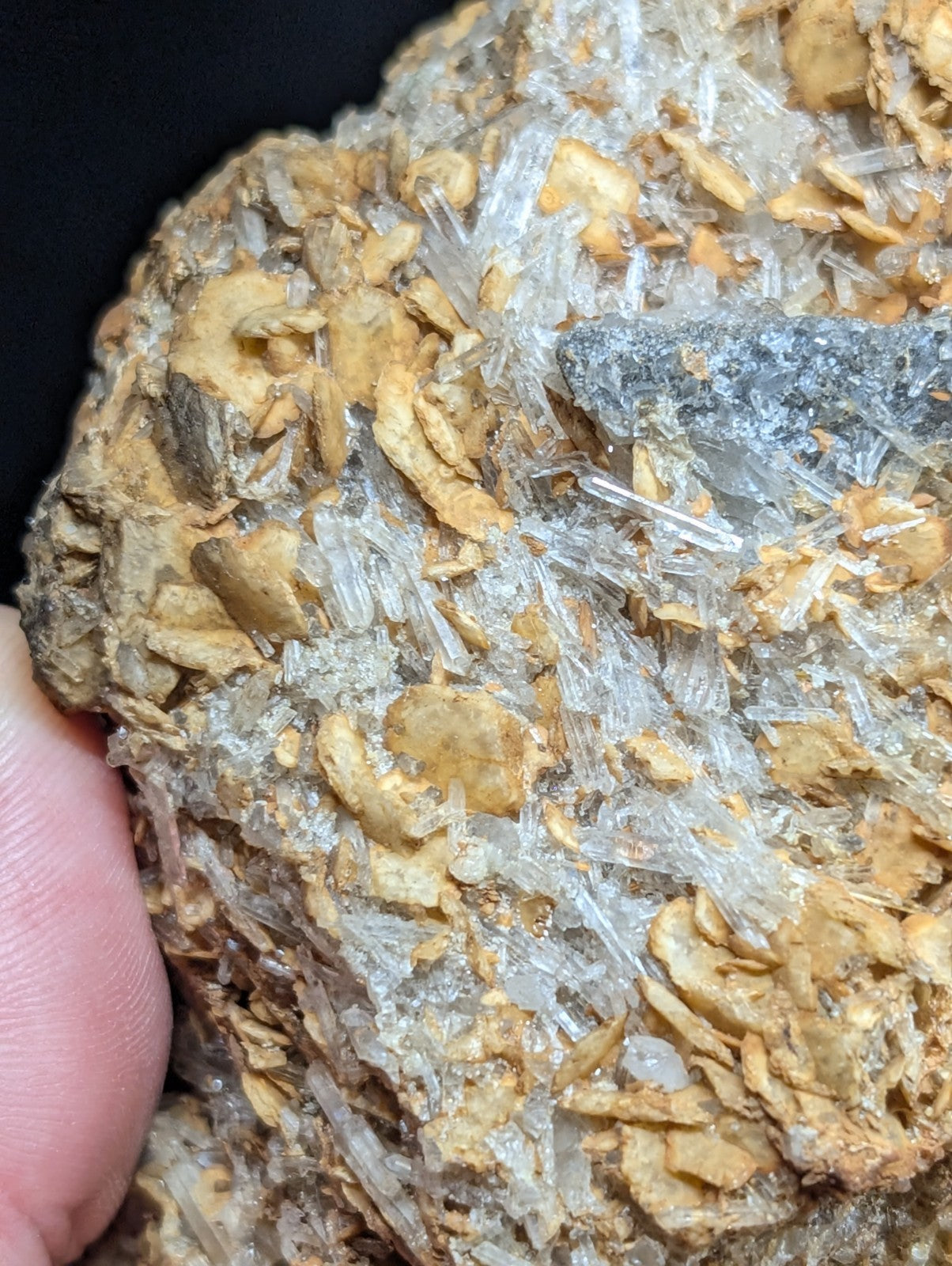 A cluster of translucent quartz crystals growing from a brownish, earthy matrix.