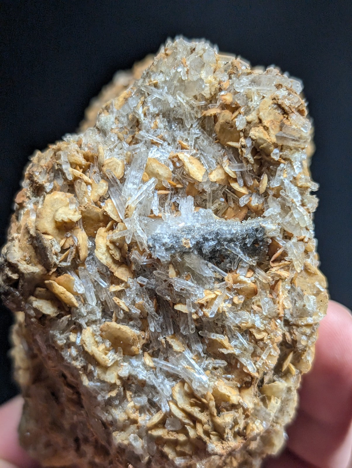 A rugged, earthy-toned mineral specimen featuring translucent quartz crystals growing from a brownish matrix.