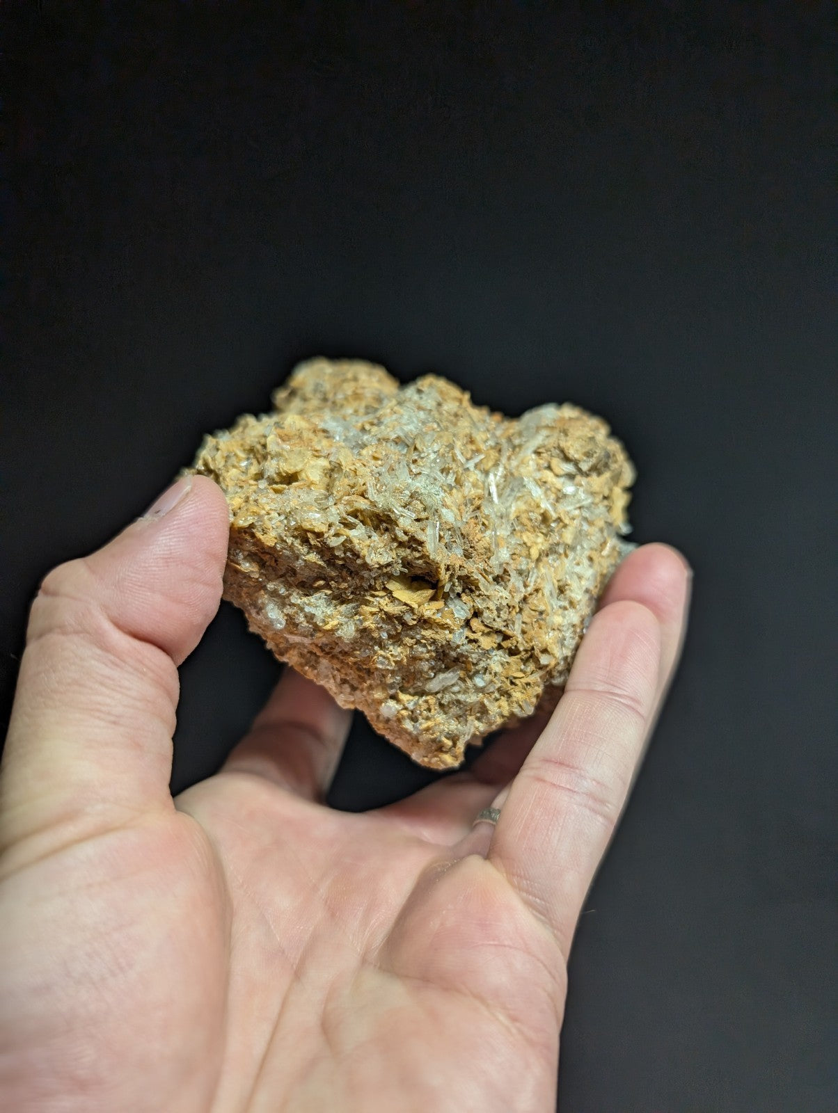 A rough, irregularly shaped mineral specimen with a mottled golden-brown and grayish surface.