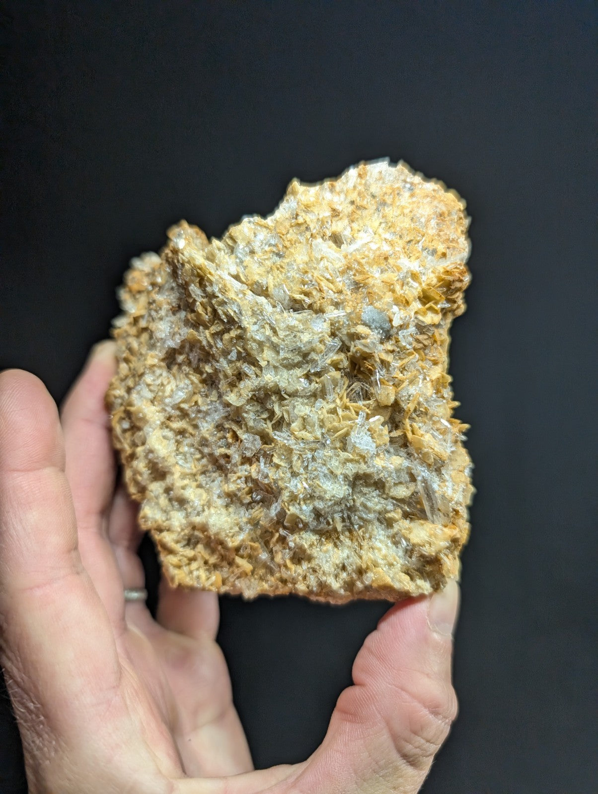 A textured, irregularly shaped mineral specimen with a mix of golden-yellow and grayish-white crystalline formations.