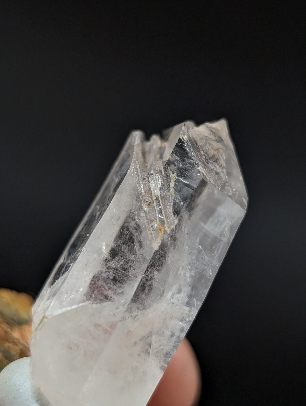 A clear, translucent quartz crystal with a pointed tip and visible internal inclusions.