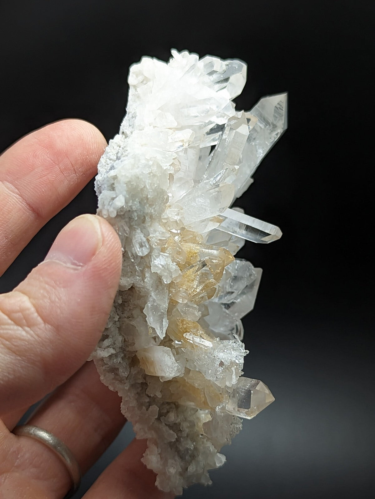 A translucent quartz crystal cluster with clear, sharp facets and a base of milky white to pale yellow mineral matrix.