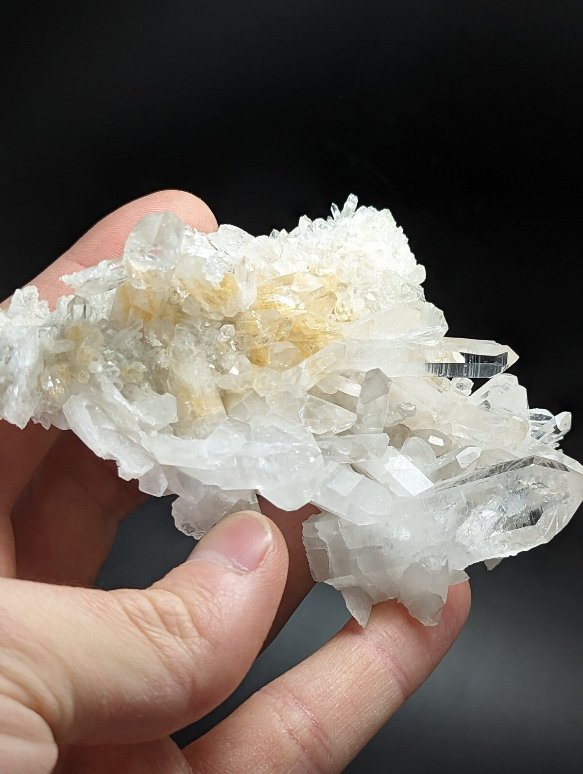 A translucent white quartz crystal cluster with delicate, interlocking facets and subtle golden-yellow inclusions.