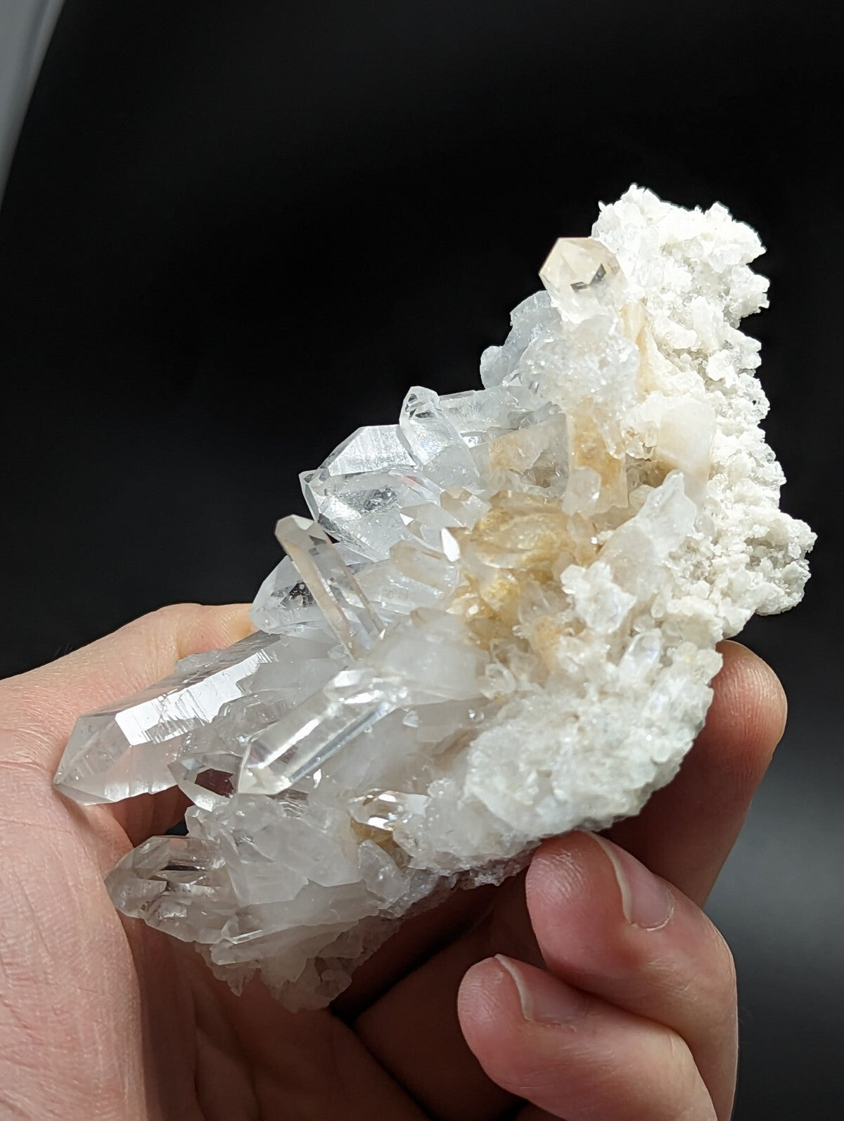 A translucent, clear quartz crystal cluster with sharp facets and a white matrix base.