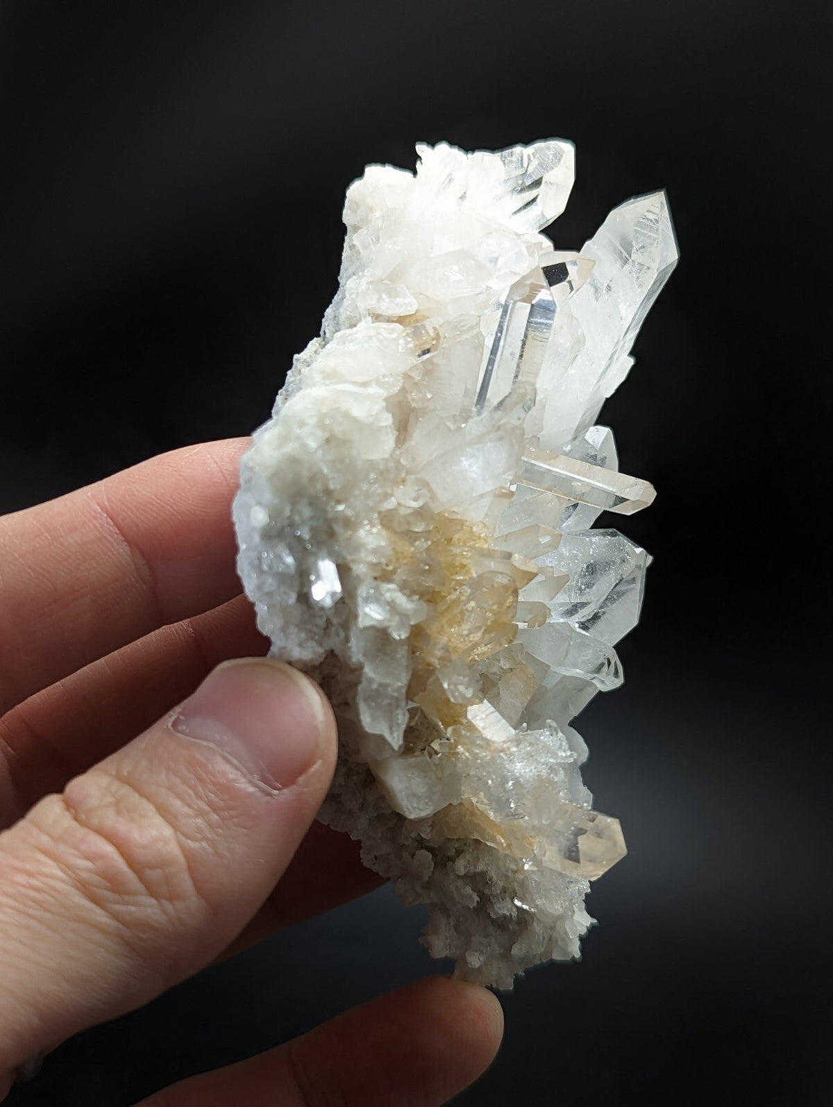 A translucent white quartz crystal cluster with sharp, faceted points and a textured base.
