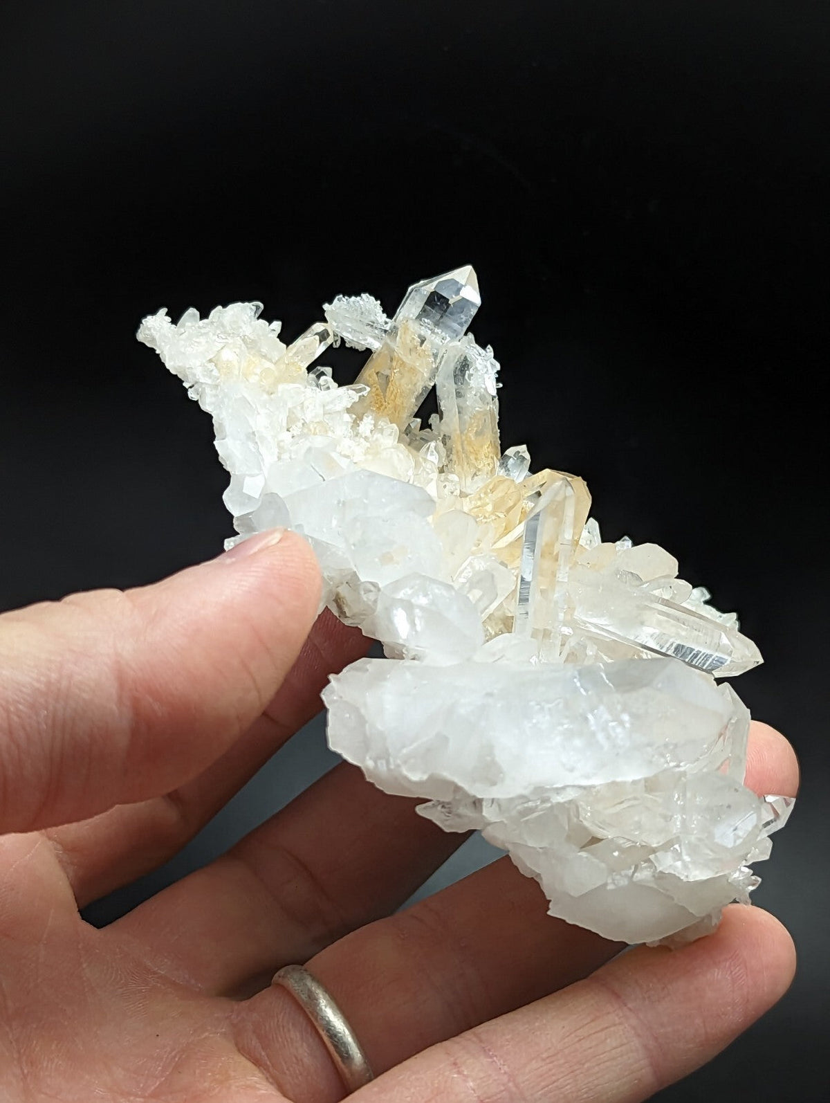A translucent white and golden crystal cluster with sharp, faceted points.