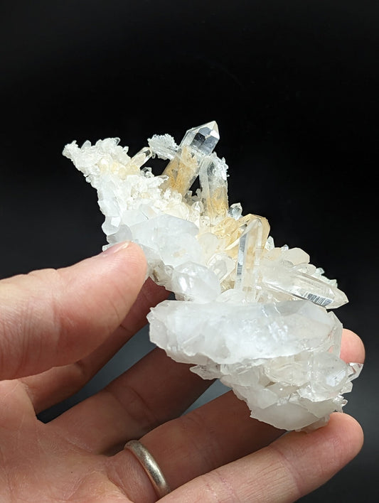 A translucent white and golden crystal cluster with sharp, faceted points.