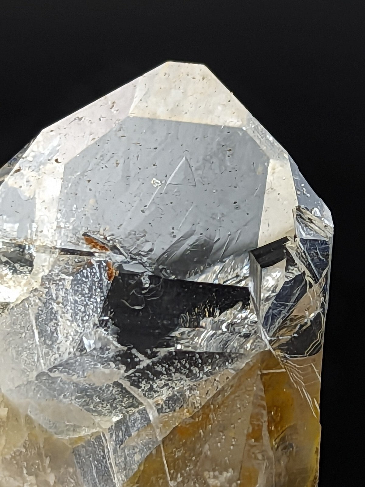A translucent, faceted quartz crystal with a clear upper section and golden-yellow base.