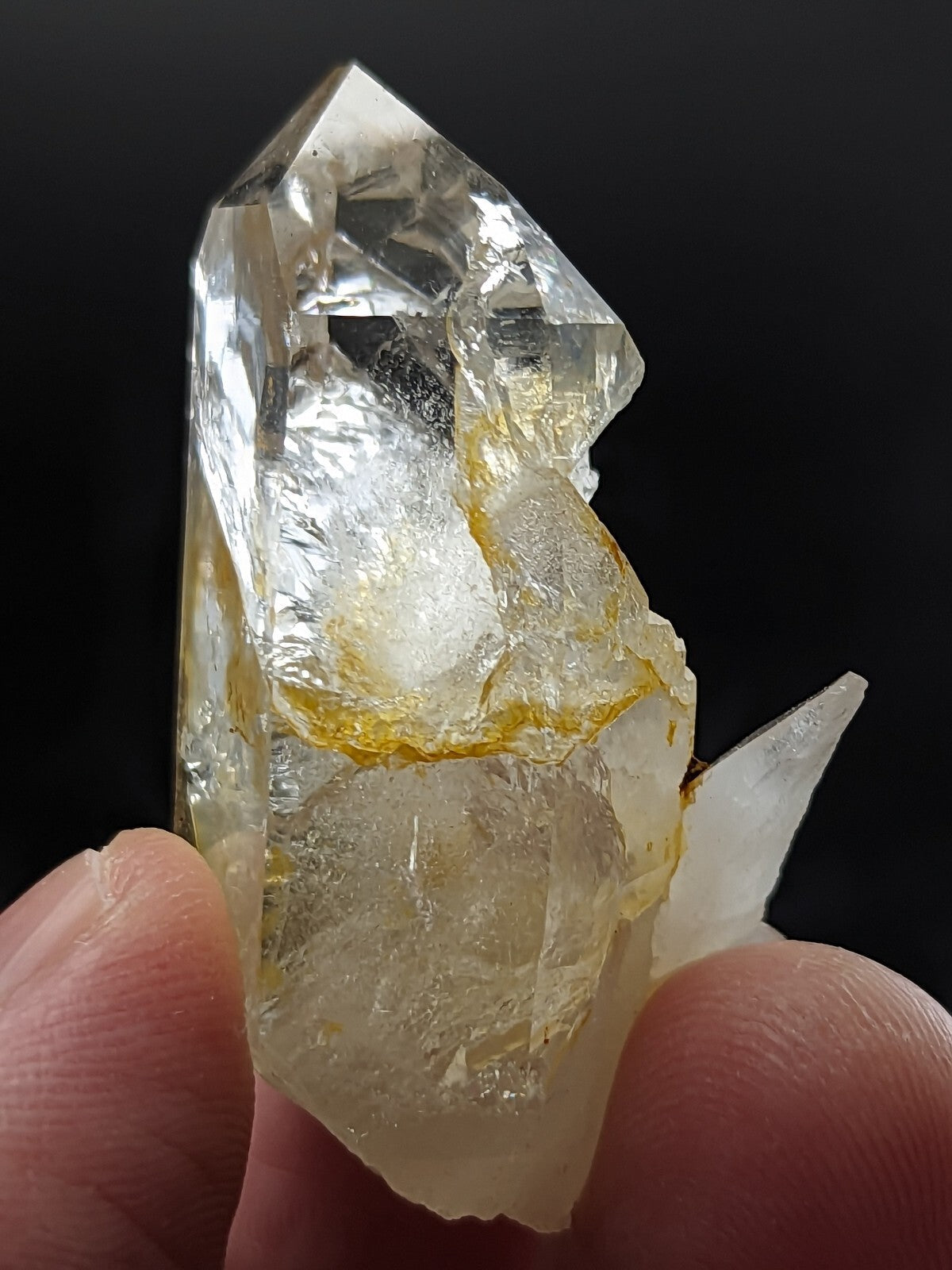 A translucent quartz crystal with a clear, glassy appearance and golden-yellow inclusions.