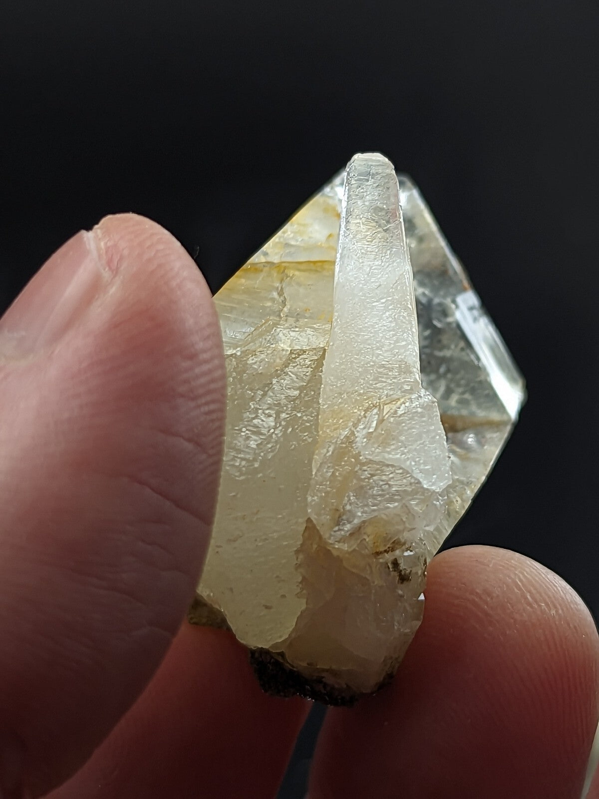 A translucent yellowish quartz crystal with a prominent, clear point and rougher base.