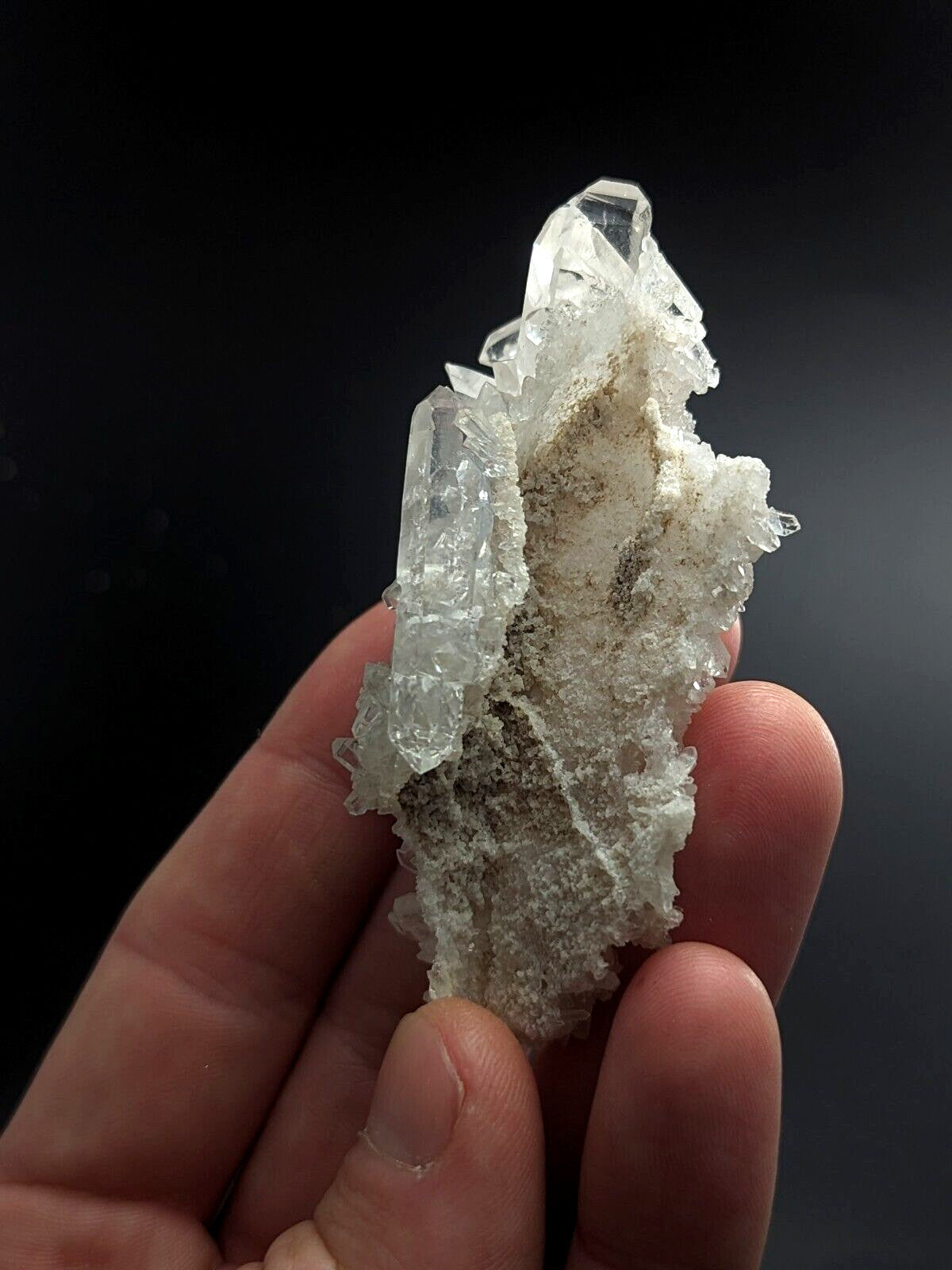A translucent quartz crystal cluster with clear, faceted points and a rougher, milky-white base.