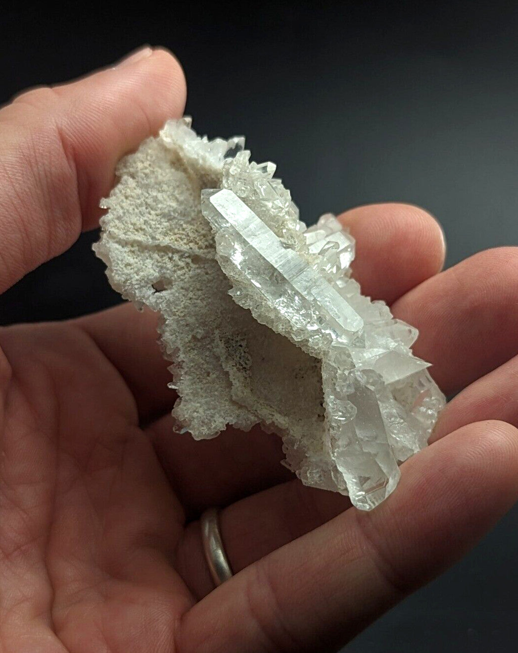 A translucent, pale quartz crystal cluster with sharp facets and a delicate, branching structure.