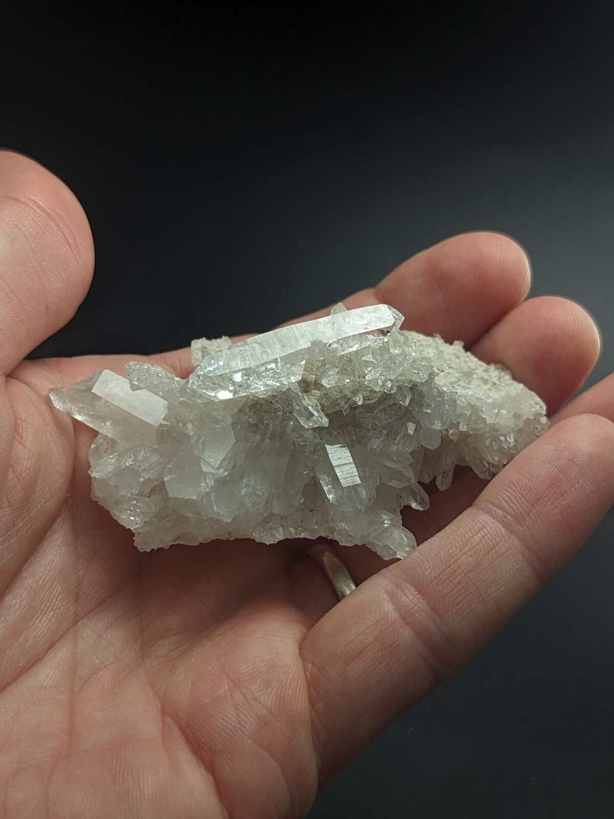 A translucent white quartz crystal cluster with sharp, faceted points and a rough, textured base.