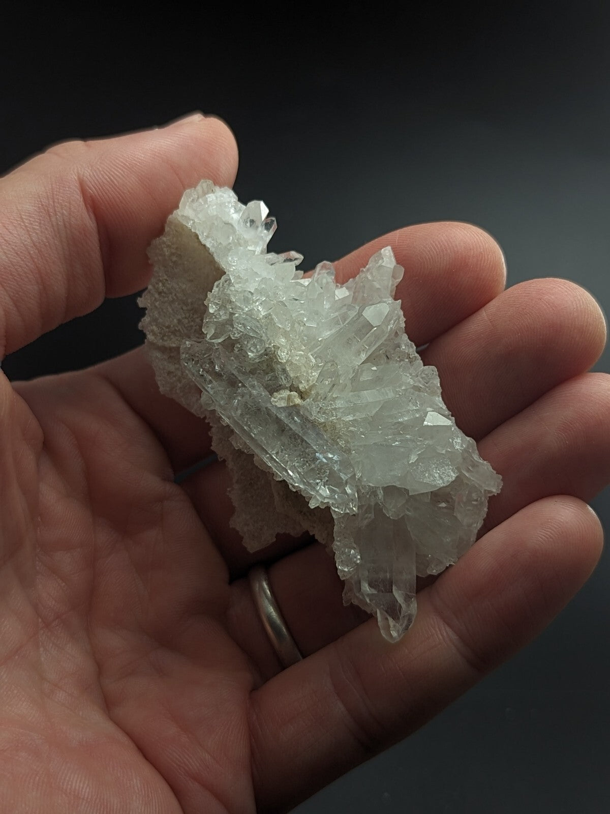 A translucent, crystalline quartz cluster with sharp, interlocking facets and a pale, milky white hue.