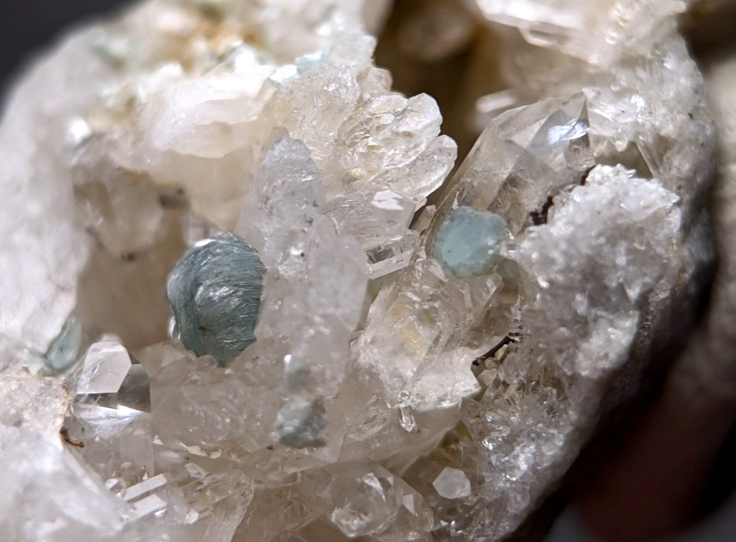 A cluster of translucent pale blue-green cookeite gemstones on clear quartz from saline county arkansas old stock uv reactive