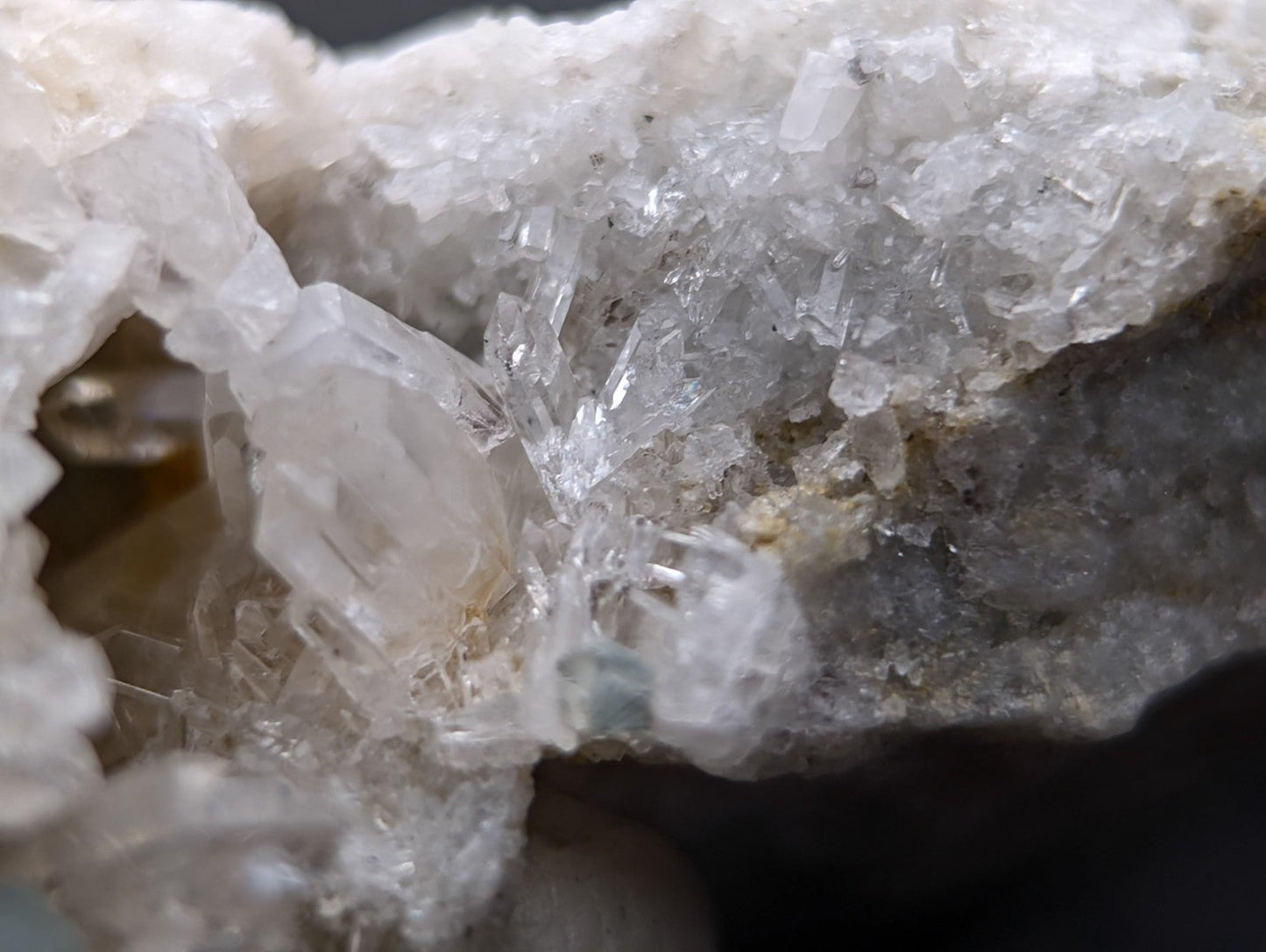 Blue green cookeite on clear quartz crystals with sharp facets on a rough gray rock matrix from saline county arkansas