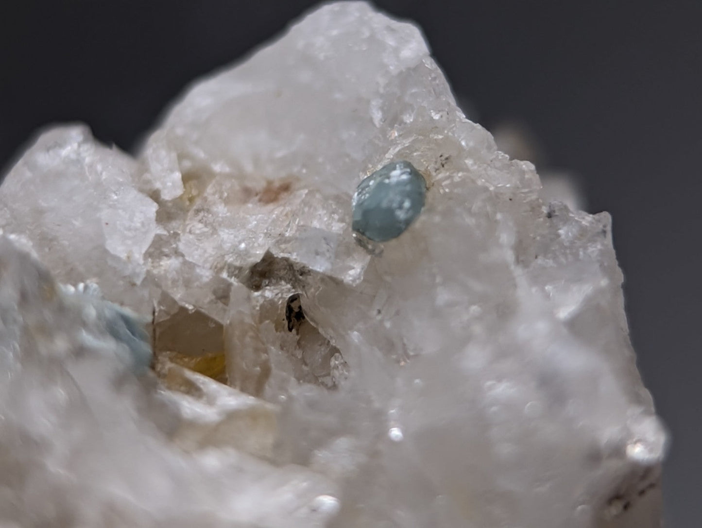 A translucent light blue blue-green cookeite gemstone nestled within clear quartz from saline county arkansas, uv reactive